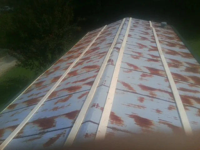 Rusted metal roof panels with new wood purlins before replacement — Storm Damage Roof Repair in Denton by Roofing Brothers