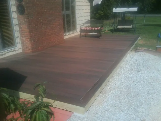 Freshly stained wood deck built against a brick home in Denton